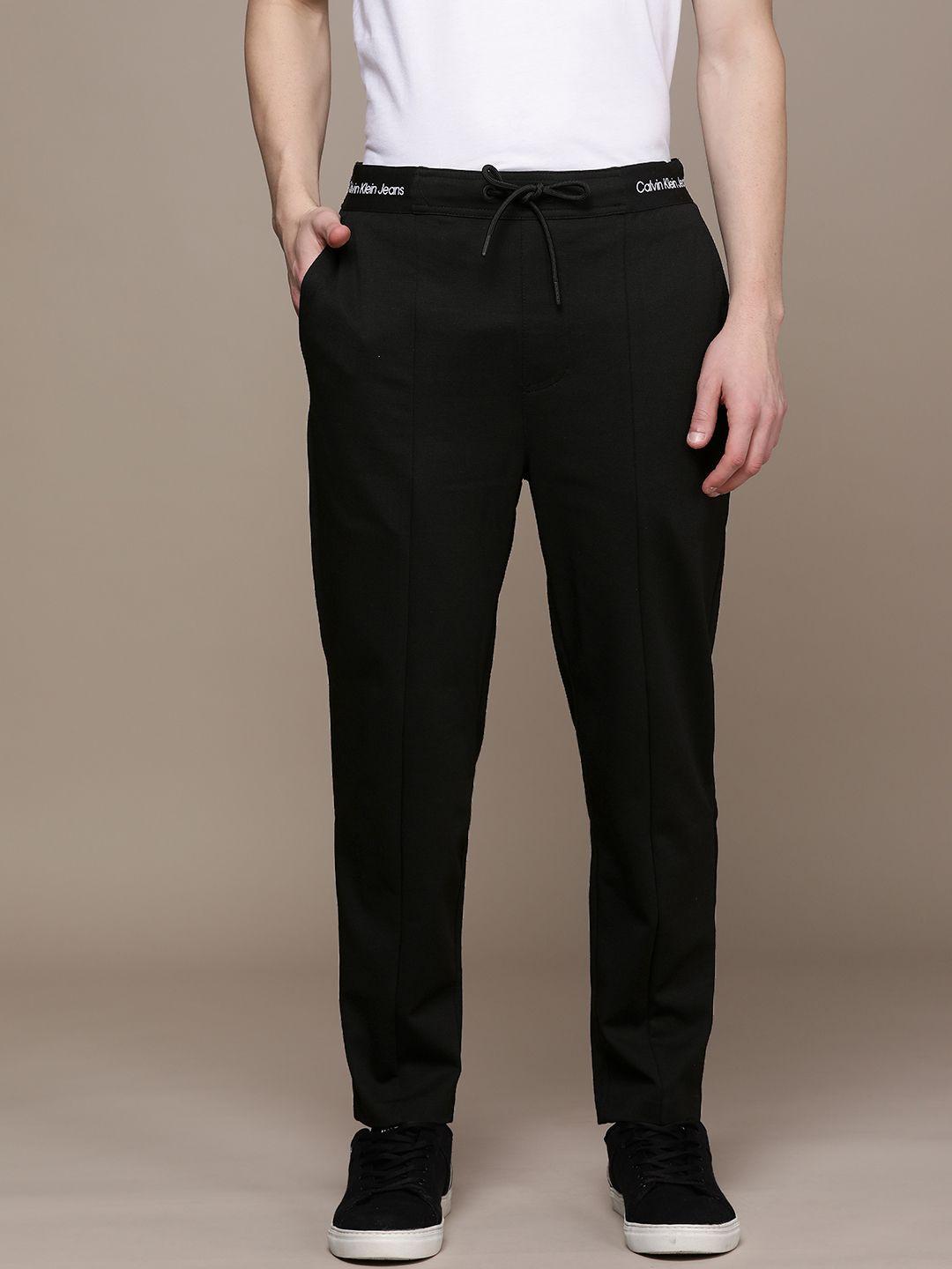 calvin klein jeans men black solid regular track pants with printed waistband