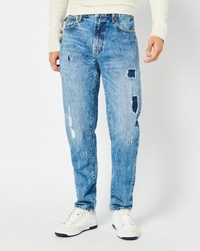 light-wash distressed tapered fit jeans