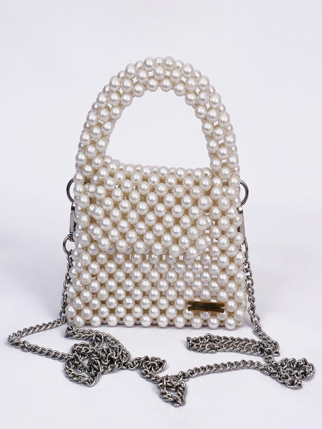 pearlfiesta cream-coloured structured handheld bag with tasselled