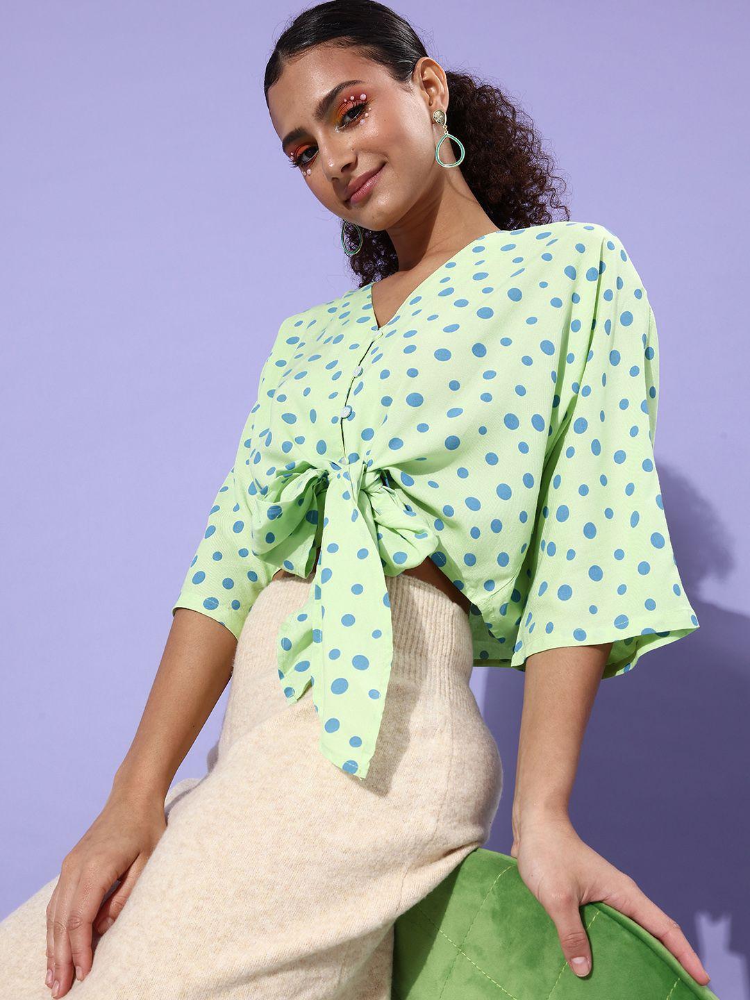 people striking green polka dotted twist & knot top