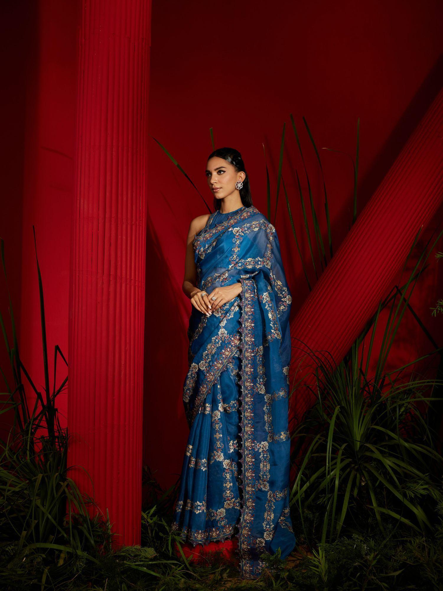 teal blue saree with a matching halter stitched blouse and petticoat