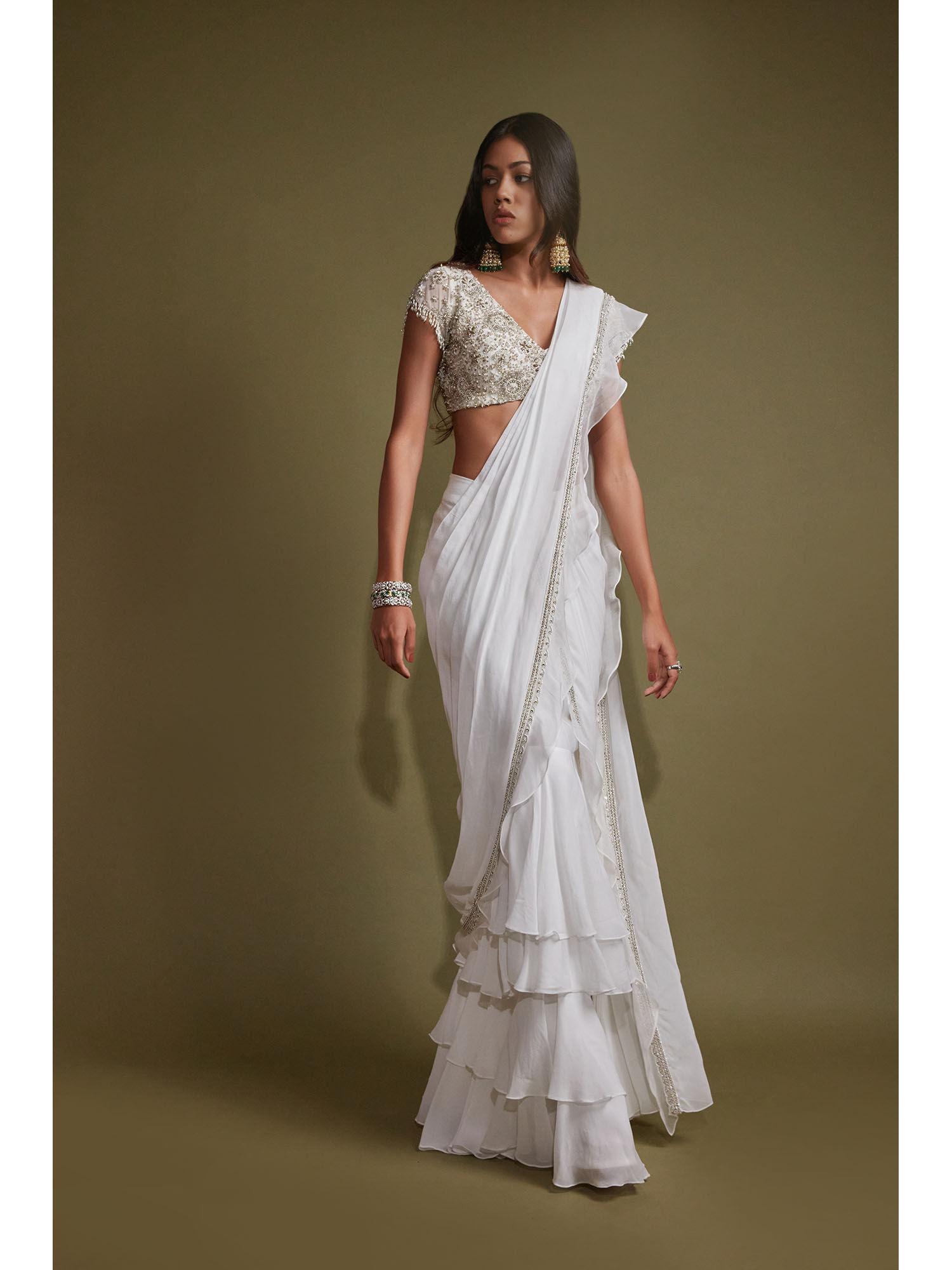 white layered saree with cap sleeve blouse with stitched