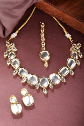 women gold kundan-studded necklace and earrings with mang tikka