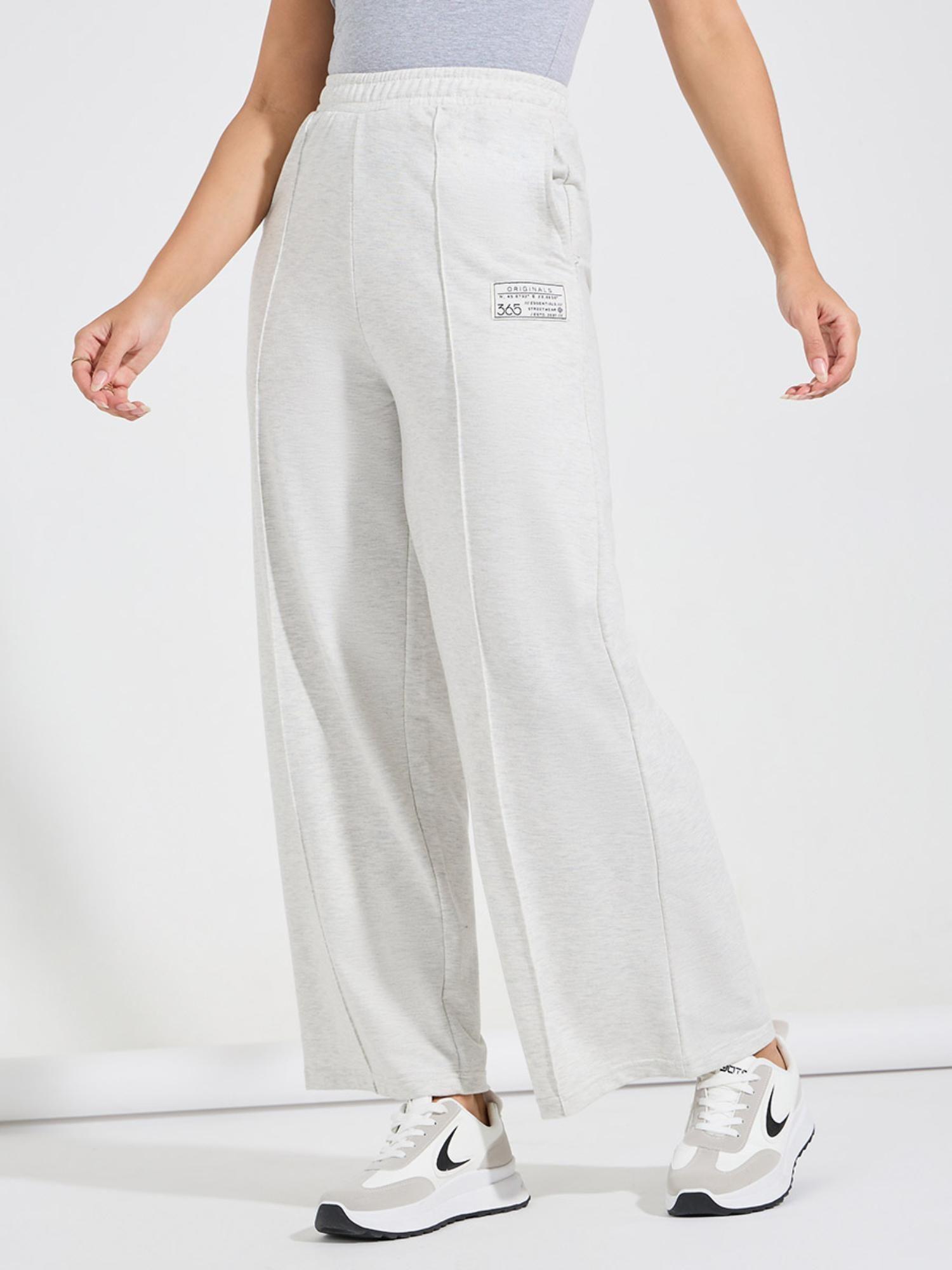 women off white solid high waisted flared leg pintuck pants with badge detail